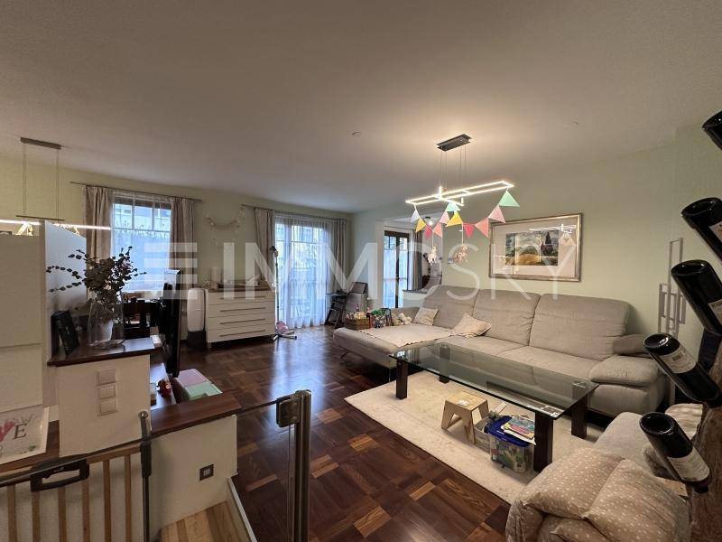 Geräumiger Wohn- und Essbereich mit Holzboden und gemütlichem Sofa.