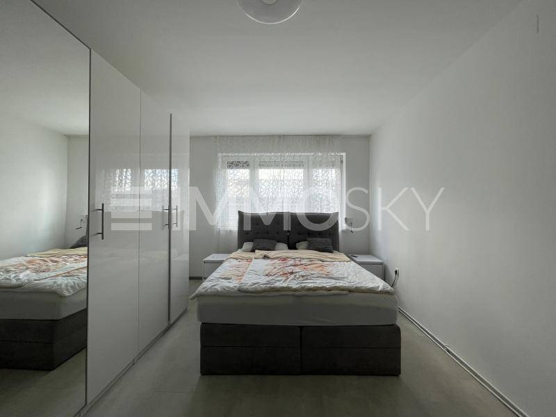 Geräumiges Schlafzimmer mit Doppelbett und großen weißen Einbauschränken.