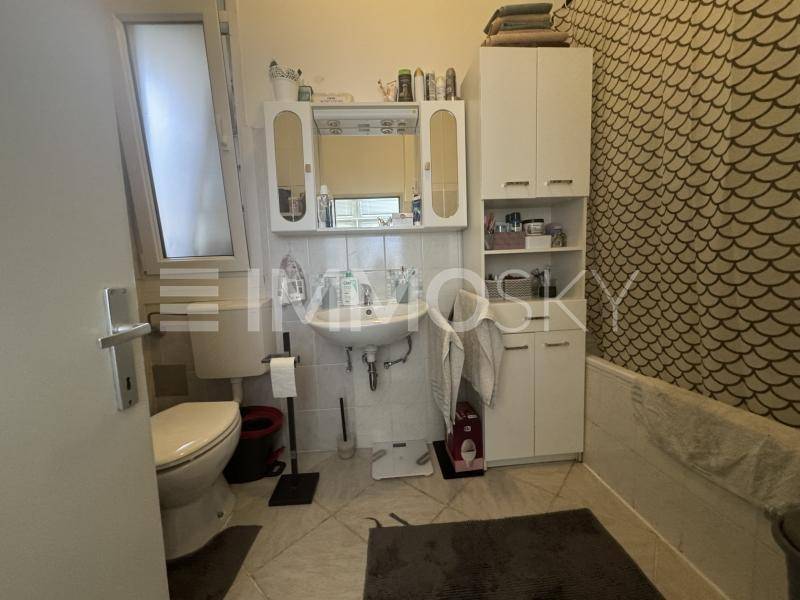Badezimmer mit Badewanne, WC, Waschbecken und einem Fenster für Tageslicht.