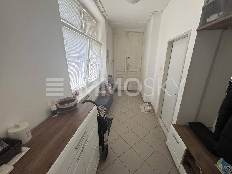 Heller Eingangsbereich mit Fliesenboden, Schuhschrank und Zugang zur Wohnungstür.
