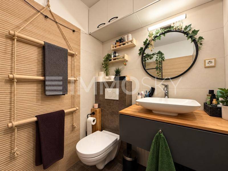 Modernes Badezimmer mit Aufsatzwaschbecken, Holzwaschtisch und einer kreativen Handtuchleiter.