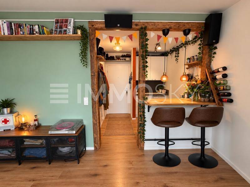 Offener Wohnbereich mit Frühstücksbar, Holzbalken und Übergang zur Küche.