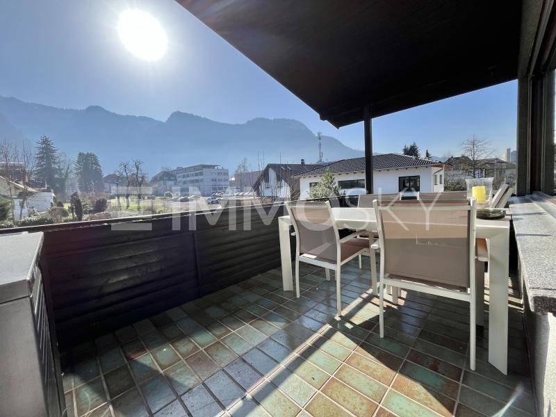 Geräumiger Balkon mit Esstisch, Stühlen und einem beeindruckenden Blick auf die umliegenden Berge.