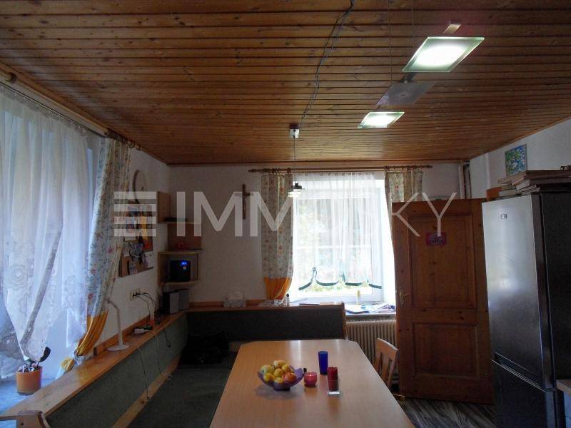 Rustikaler Essbereich mit Holztäfelung an der Decke, einer Eckbank und einem großen Holztisch.