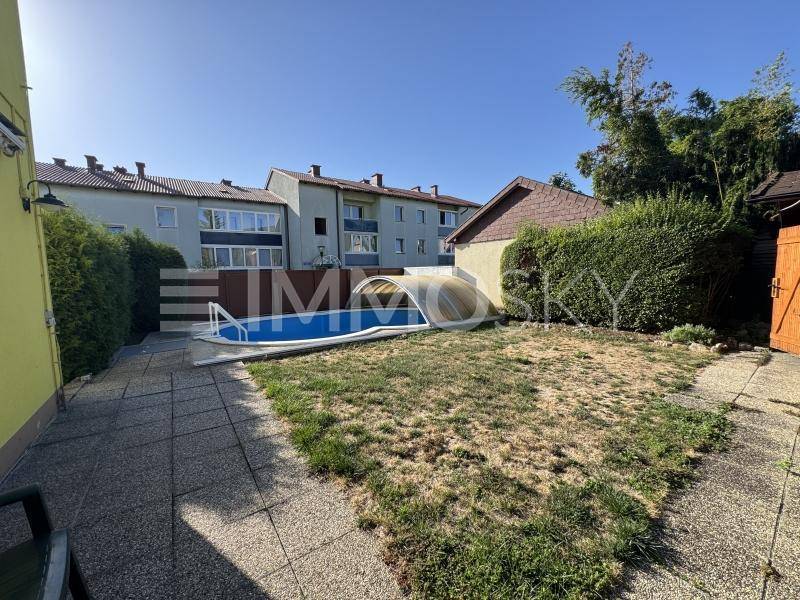 Gartenbereich mit kleinem Pool und gepflasterter Terrasse hinter dem Haus.
