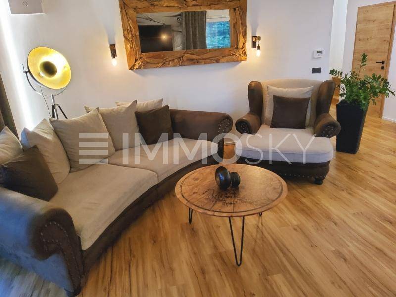 Gemütlicher Wohnbereich mit bequemen Sofas, Holzboden und rustikalem Spiegel.