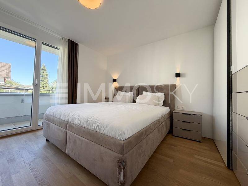 Gemütliches Schlafzimmer mit großem Bett, Nachttischen und direktem Zugang zum Balkon.
