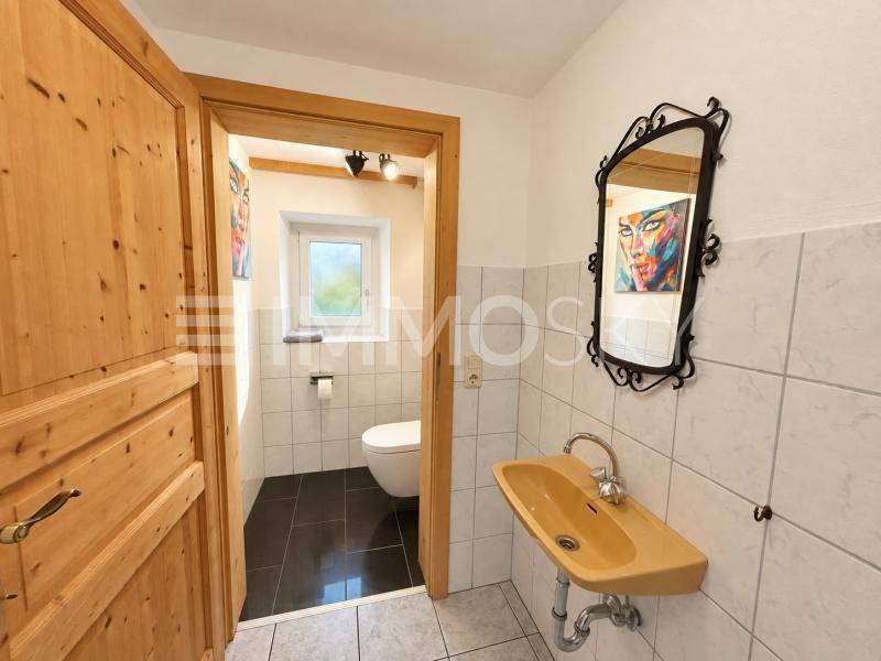 Kleines Gäste-WC mit Fenster, Wand-WC und einem Waschbecken in Gelb.