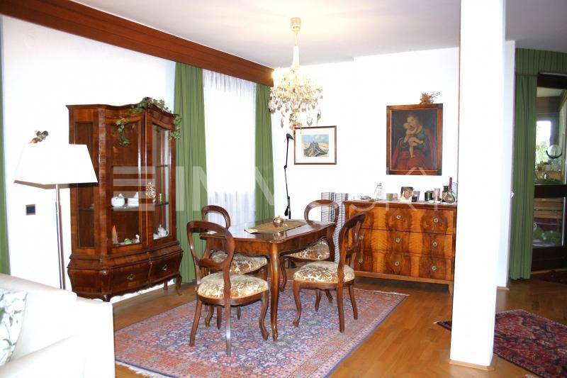 Eleganter Essbereich mit dunklen Holzmöbeln, Kronleuchter und Parkettboden.