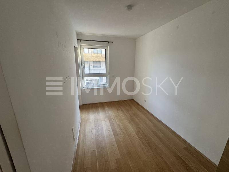 Ruhiges Zimmer mit Parkettboden und Fenster, ideal als Schlaf- oder Arbeitszimmer.