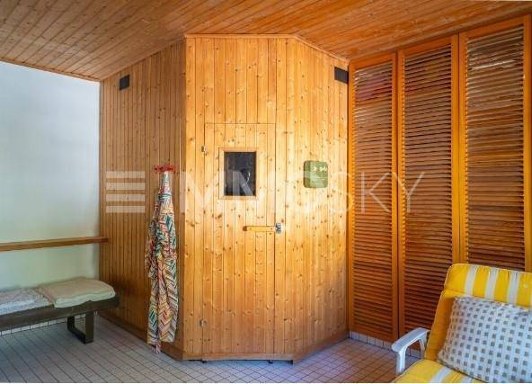 Holzvertäfelte Sauna mit Sitzbänken und einem Bereich zum Entspannen.