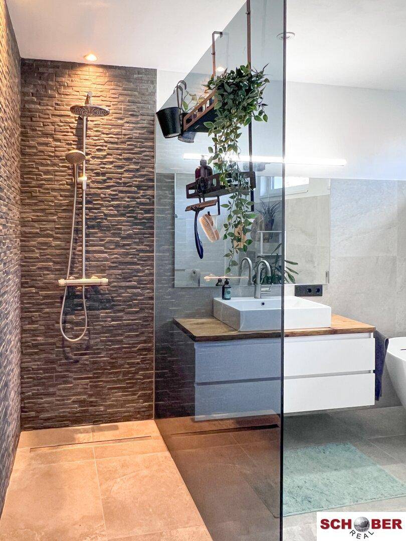 Modernes Badezimmer mit begehbarer Dusche, Steinwandfliesen und Aufsatzwaschbecken.