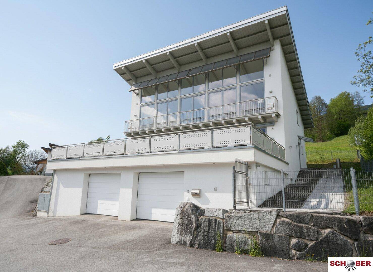 Moderne Hausfassade mit Doppelgarage und gepflegter Außenanlage.