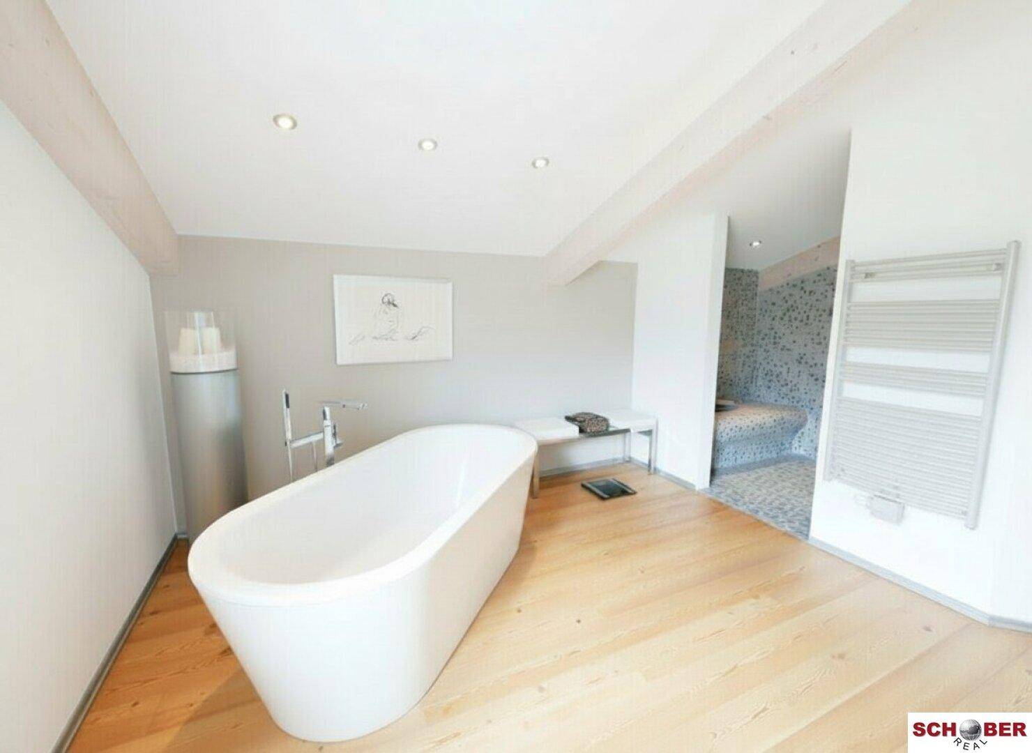 Luxuriöses Badezimmer mit freistehender Badewanne und Wellnessbereich.