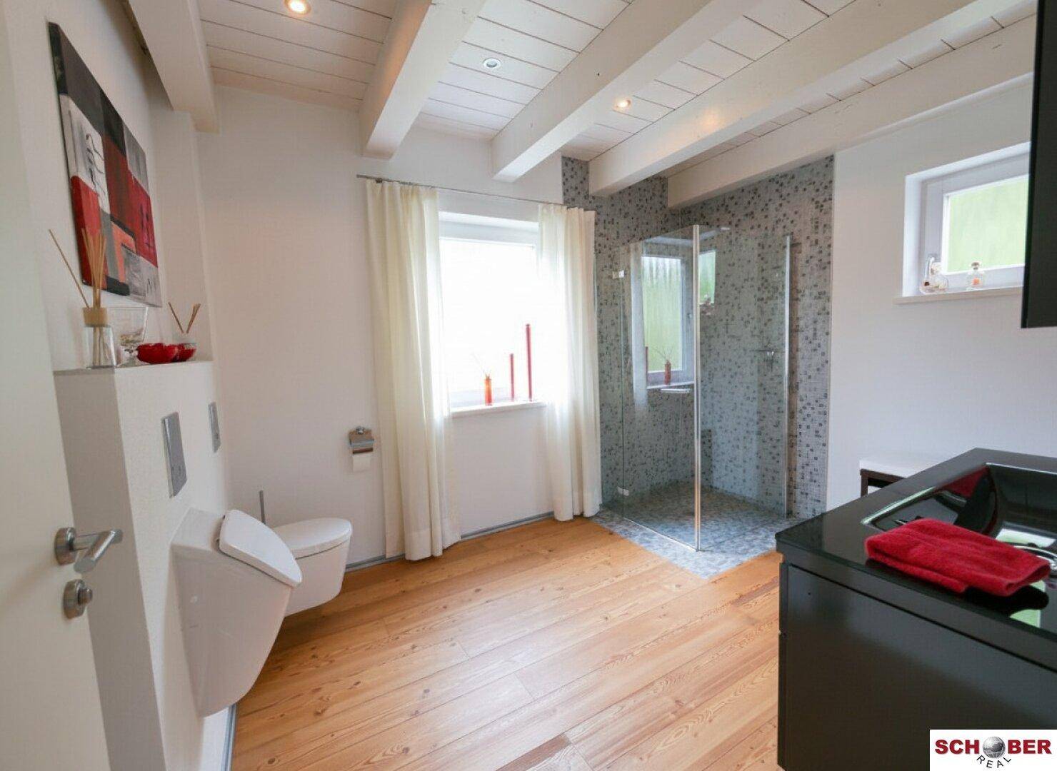 Modernes Badezimmer mit begehbarer Dusche, Wand-WC und Holzfußboden.