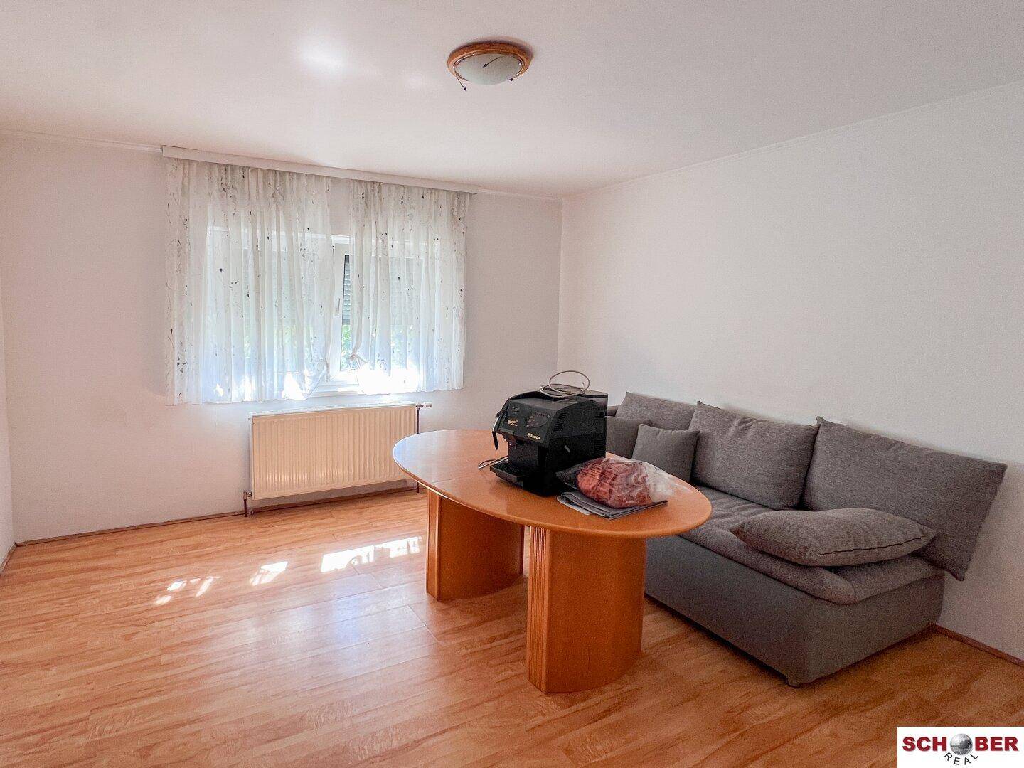 Helles Zimmer mit Laminatboden und einem Fenster, das viel Tageslicht bietet, ideal als Büro.