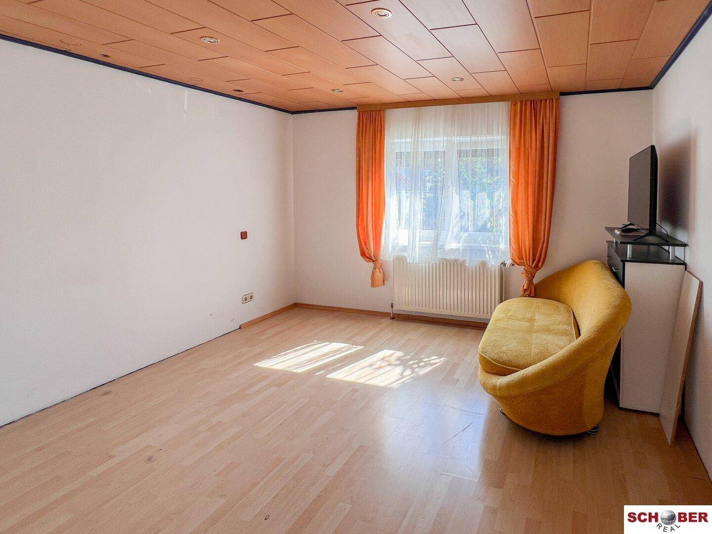 Gemütliches Zimmer mit Holzboden und einer gelben Couch, ideal zum Entspannen und Verweilen.