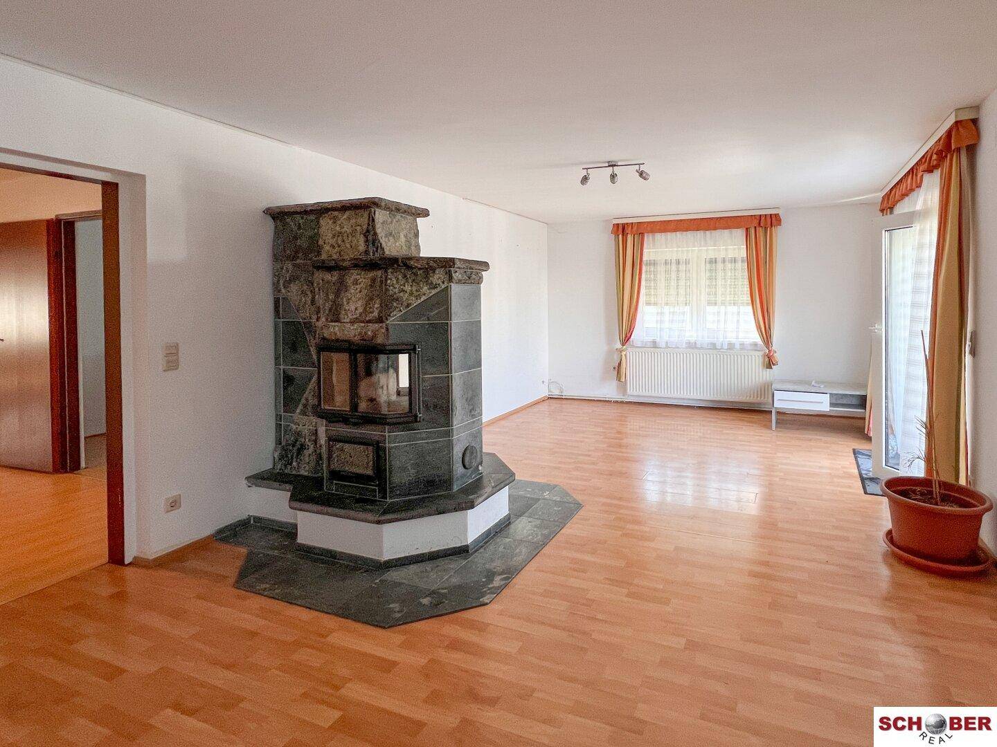Geräumiges Wohnzimmer mit Parkettboden und einem Kamin als zentralem Element für Gemütlichkeit.