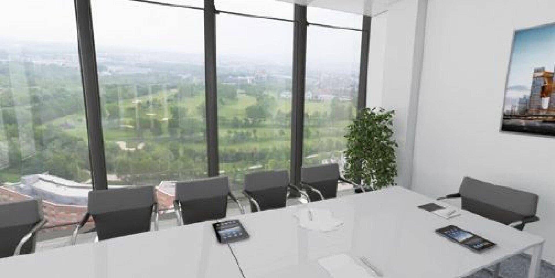 Moderner Konferenzraum mit großem Tisch, bequemen Stühlen und weitem Blick ins Grüne.