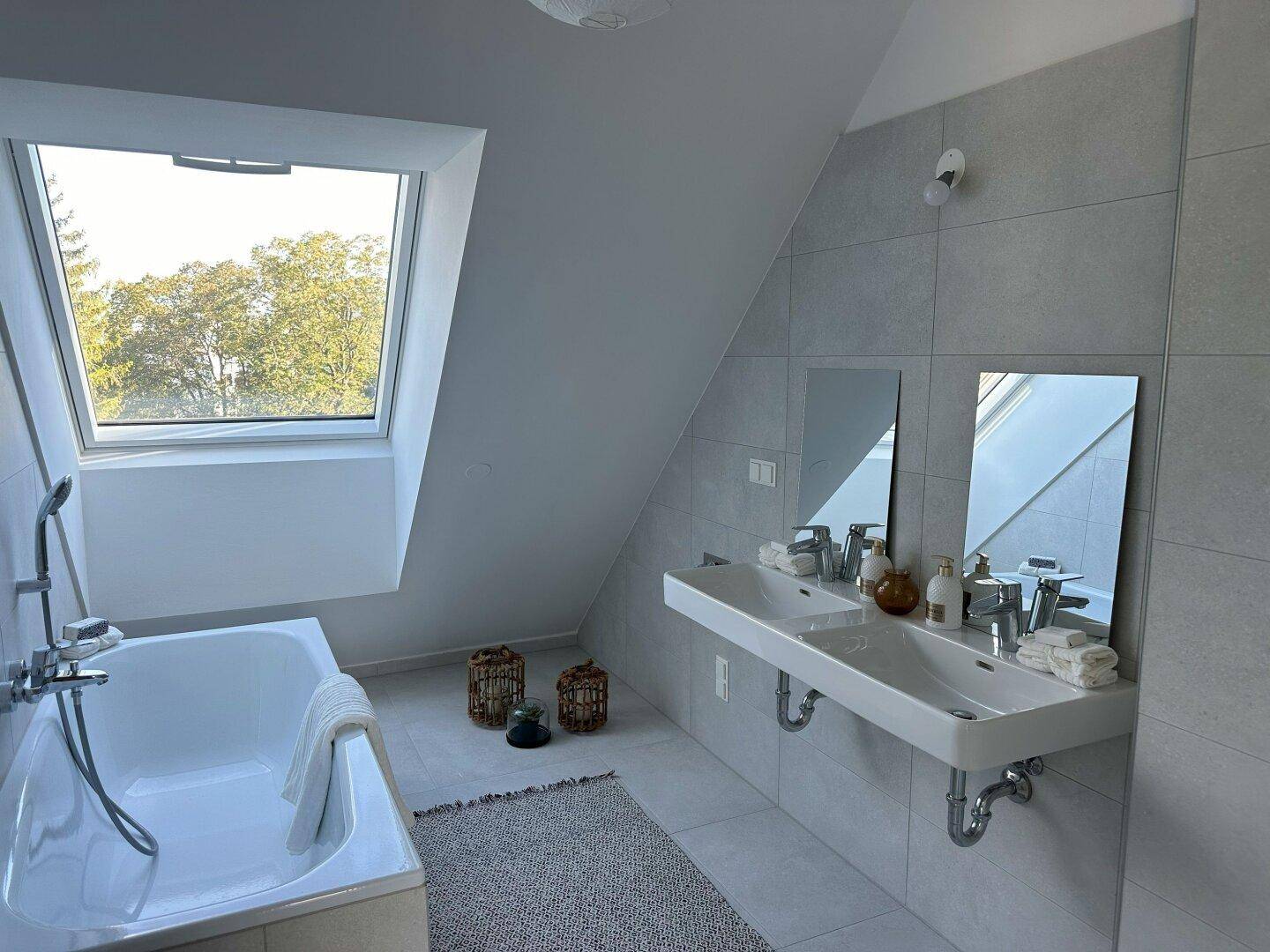 Geräumiges Badezimmer mit Dachfenster, Doppelwaschbecken und Badewanne.