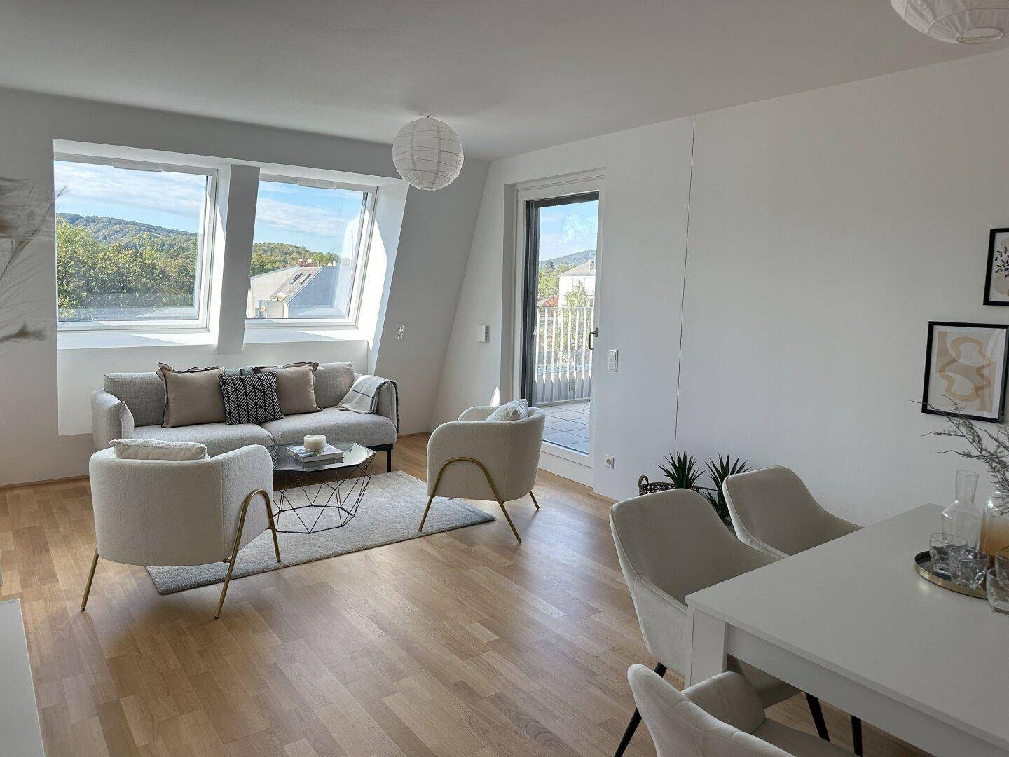 Offener Wohn- und Essbereich mit Holzboden, Dachschrägen und Zugang zur Terrasse.