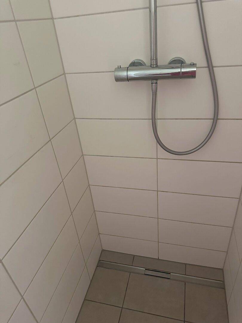Bodengleiche Dusche mit modernen Fliesen und einem linearen Abfluss für barrierefreien Zugang.