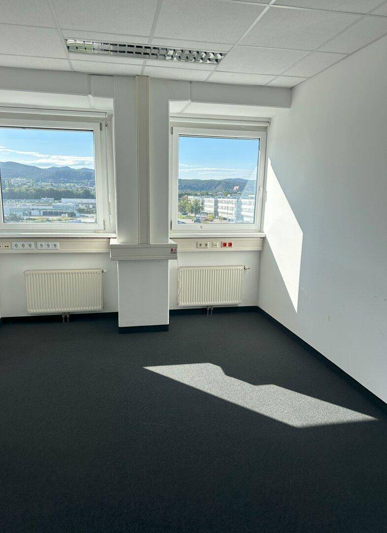 Geräumiges Büro mit Teppichboden, Heizkörpern und weitem Ausblick auf die Landschaft.
