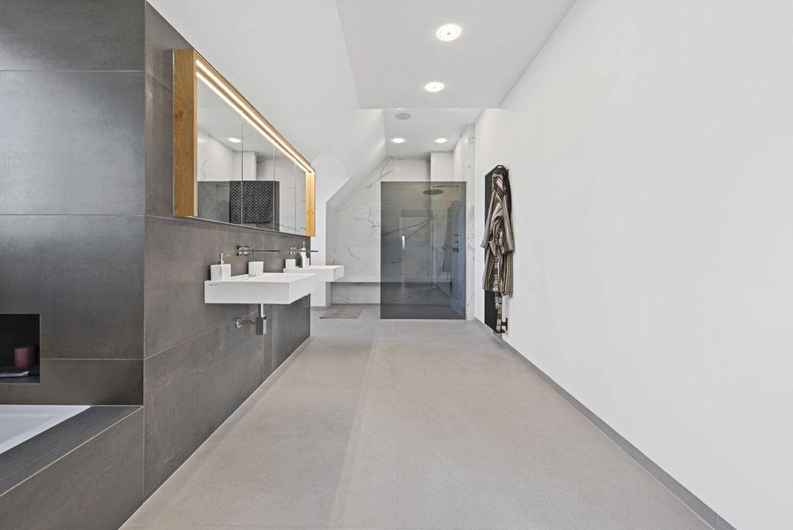 Geräumiges, modernes Badezimmer mit Doppelwaschbecken, integrierter Badewanne und großer begehbarer Dusche.