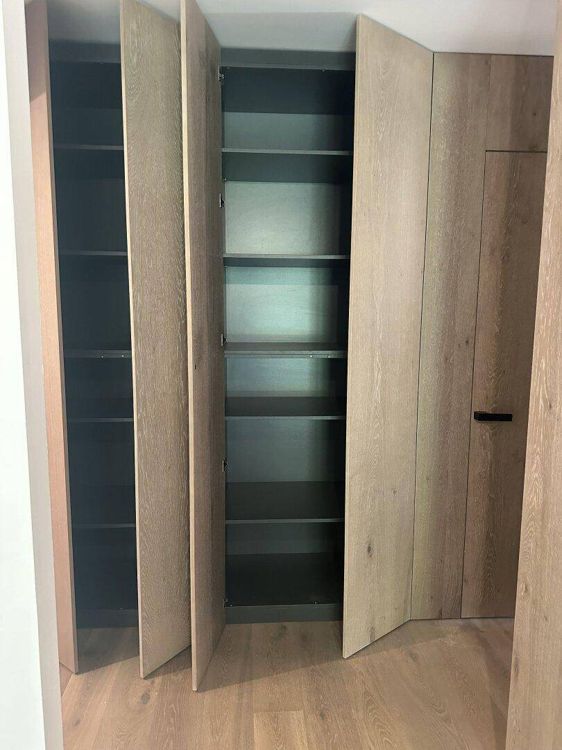 Heller Flur mit integrierten Holzschränken, die viel Stauraum bieten.