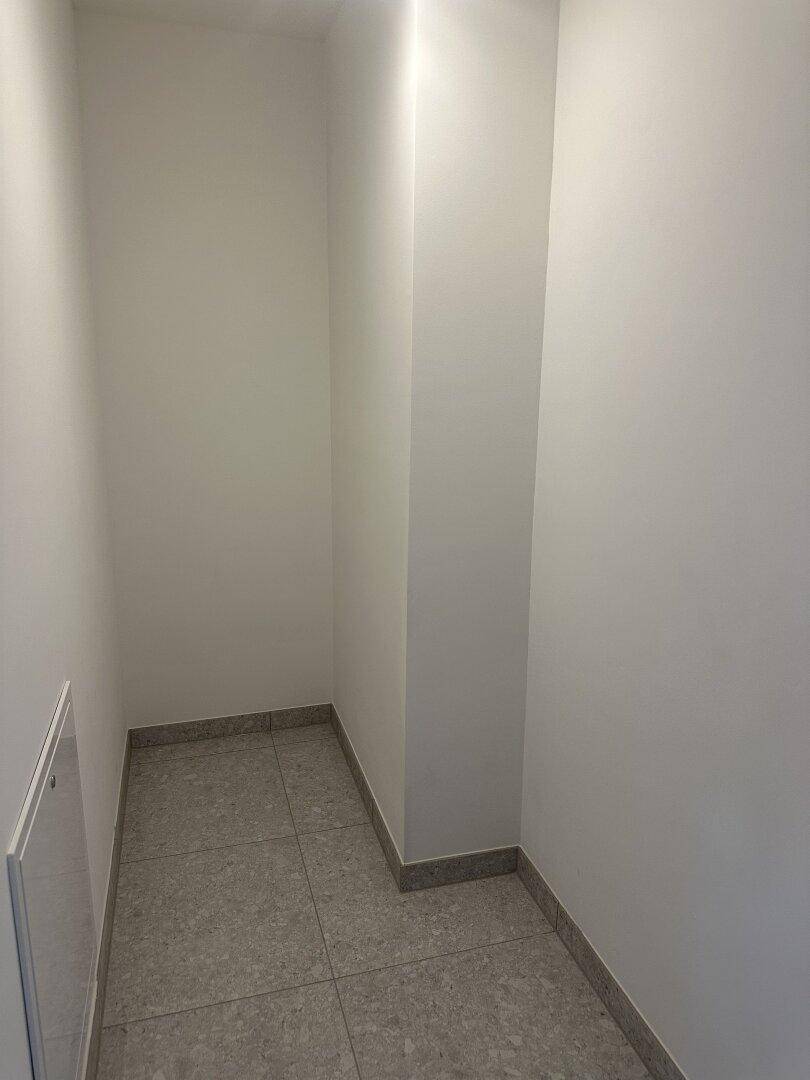 Praktischer Abstellraum mit Fliesenboden und hellen Wänden für zusätzlichen Stauraum.