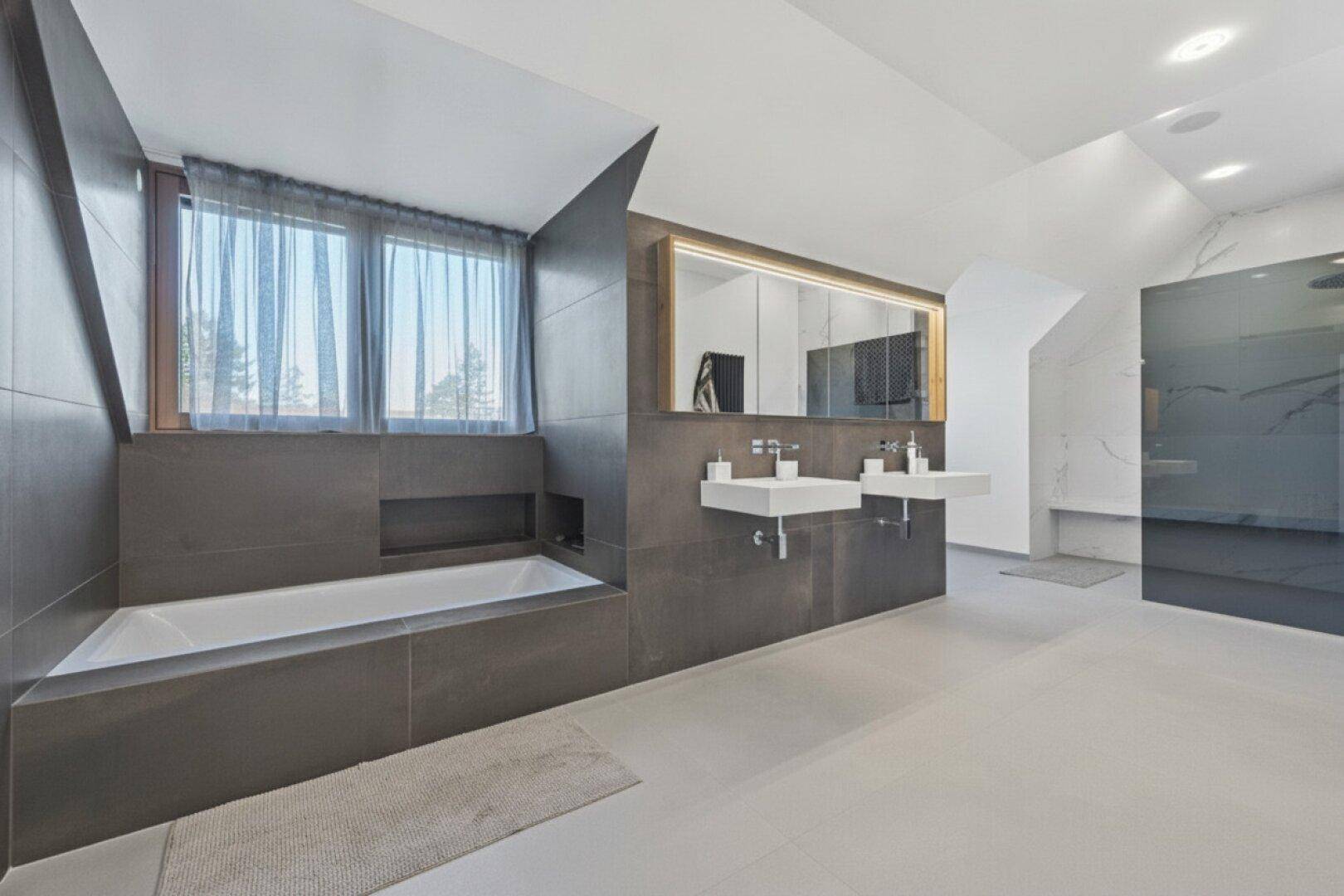 Elegantes Badezimmer mit integrierter Badewanne unter dem Fenster, Doppelwaschbecken und begehbarer Dusche.