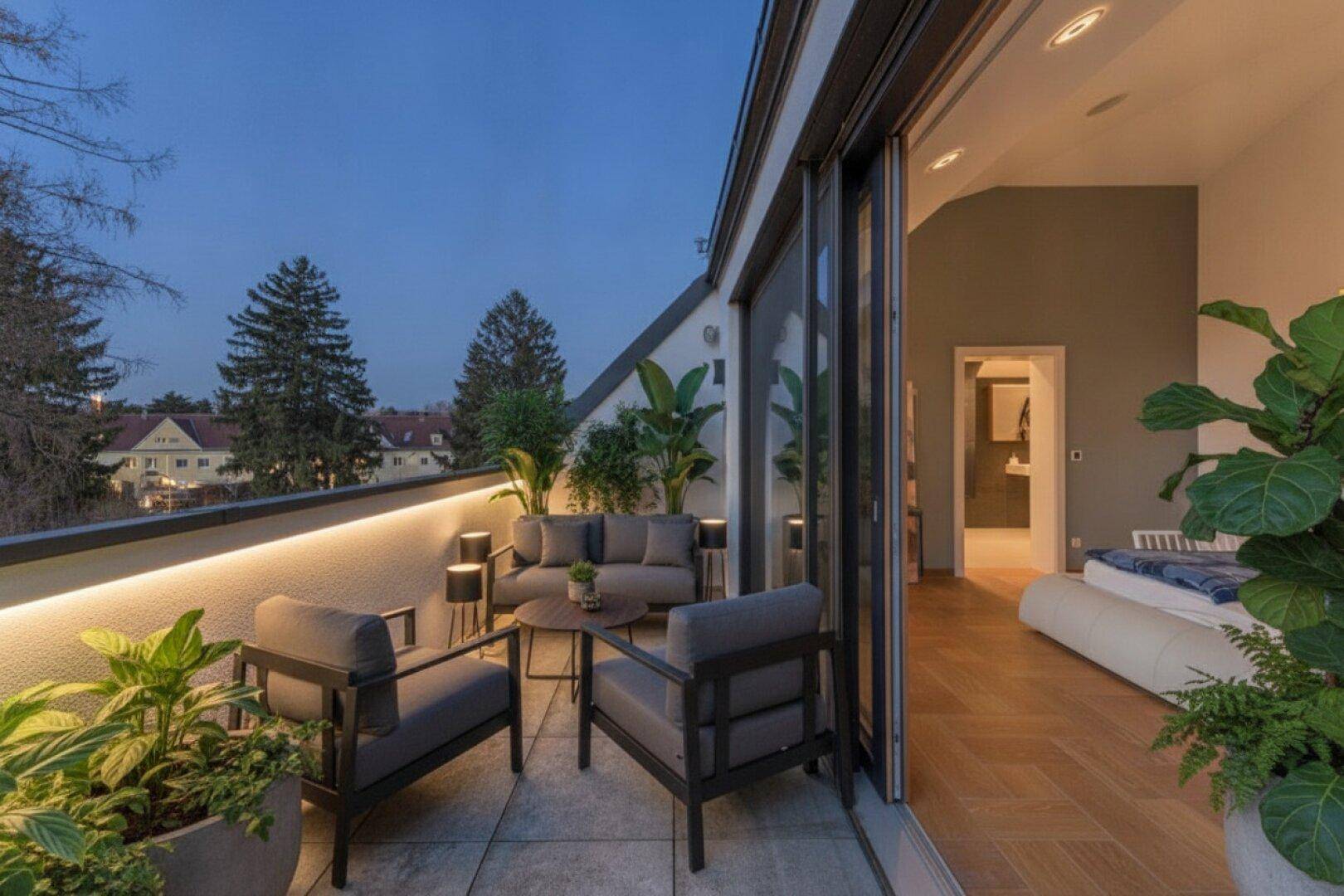 Gemütlicher Balkon mit stilvollen Loungemöbeln und Pflanzen, perfekt für entspannte Abende im Freien.