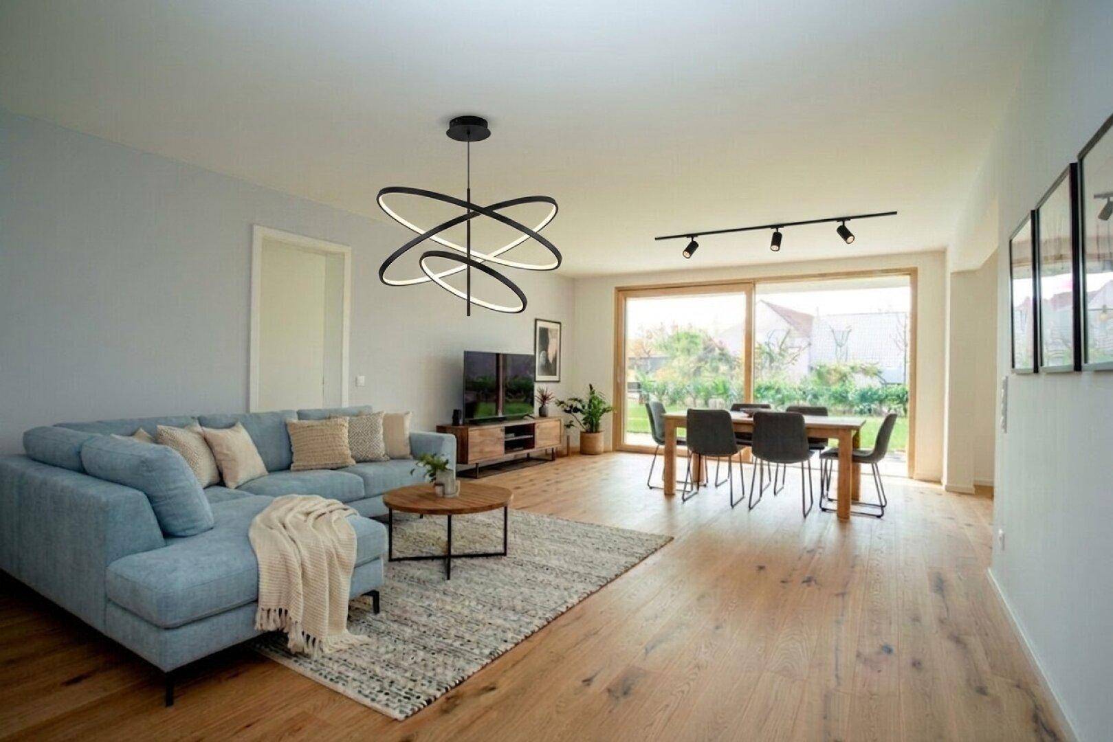 Heller offener Wohn-Essbereich mit Holzboden, modernem Sofa und direktem Zugang zum Garten.