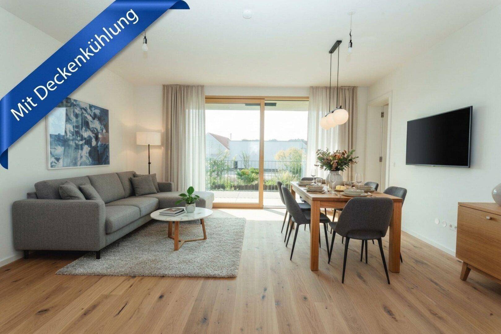 Heller Wohn- und Essbereich mit Holzboden, großen Fenstern und Zugang zum Balkon.