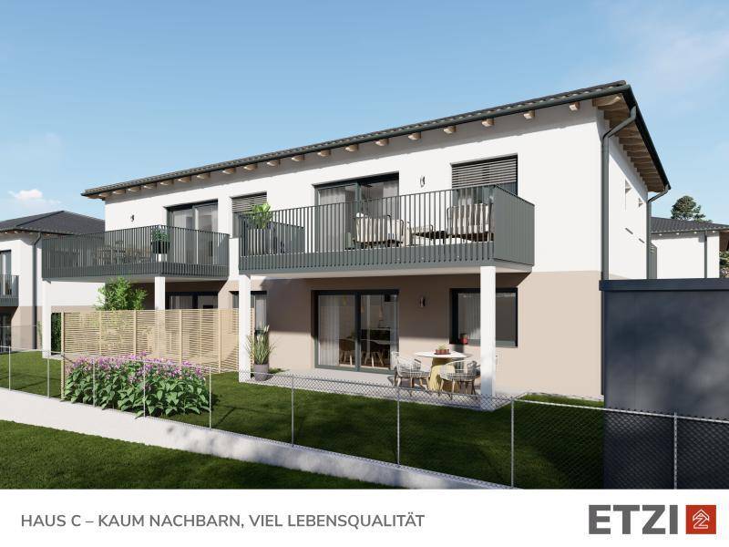 Moderne Fassade eines Neubaus mit Balkonen und Terrassen in ländlicher Umgebung.
