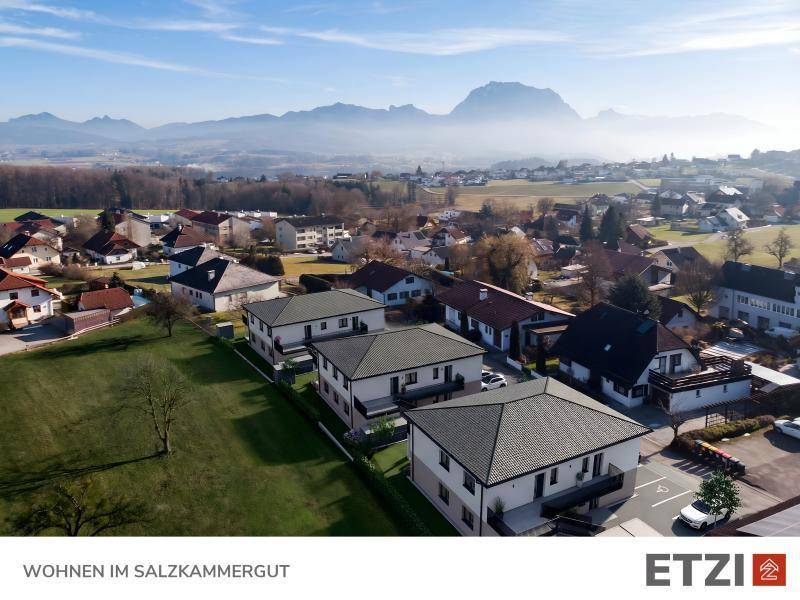 Luftaufnahme einer Wohnsiedlung mit Neubauten und malerischem Bergblick im Salzkammergut.