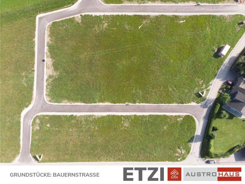 Detailansicht von erschlossenen Baugrundstücken mit angelegten Straßen und grünen Flächen aus der Vogelperspektive.