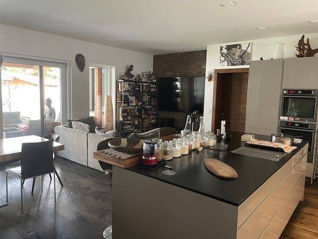 Geräumiger offener Wohnbereich mit Kücheninsel, Sofa und Bücherregal, ideal für geselliges Beisammensein.