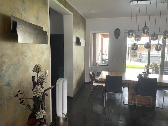 Eingangsbereich mit dekorativer Wandgestaltung und Blick auf den Essbereich und den Garten.