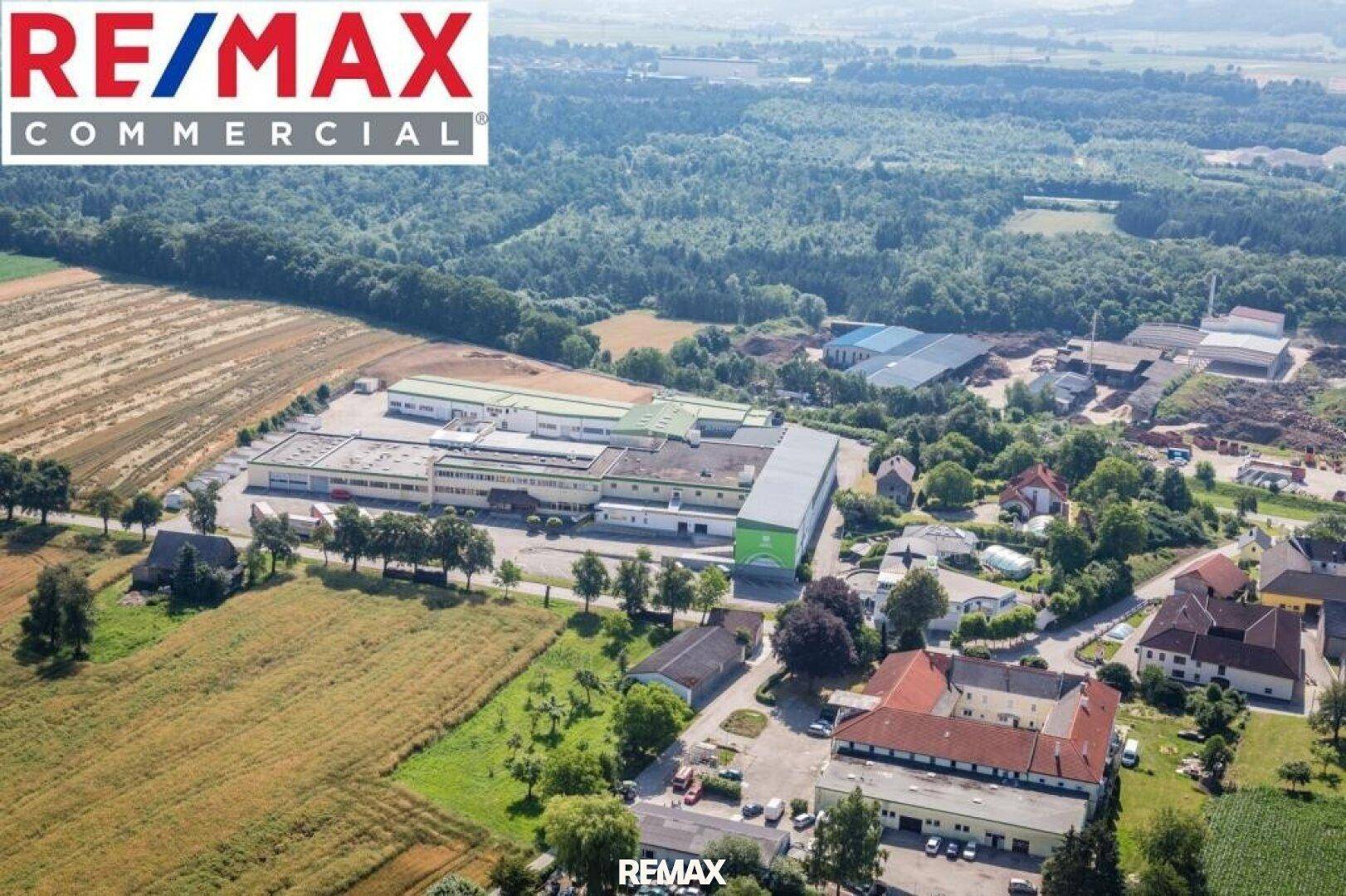 Luftaufnahme eines großen Gewerbekomplexes, umgeben von Feldern und grüner Landschaft.