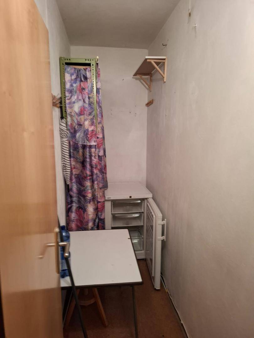 Abstellraum mit Gefrierschrank, Regal und Vorhang.