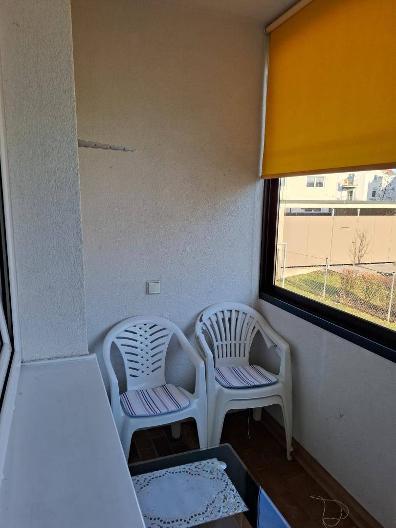 Gemütliche Loggia mit Gartenmöbeln und Blick ins Grüne.