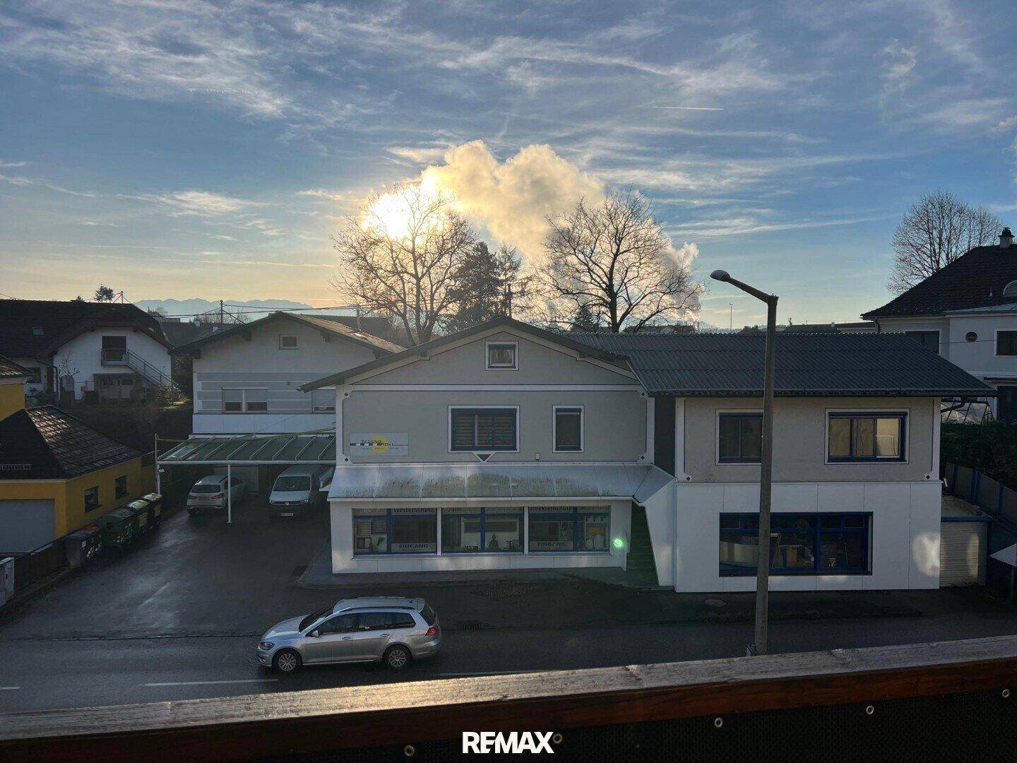 Gebäudeansicht von der Straße aus an einem sonnigen Tag mit Wolken am Himmel.