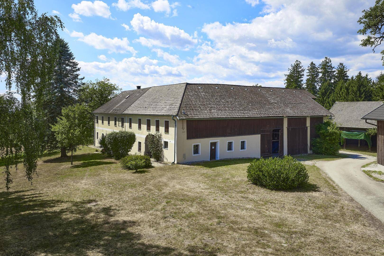 Luftaufnahme eines weitläufigen, traditionellen Landhauses mit großem Grundstück und Nebengebäuden.