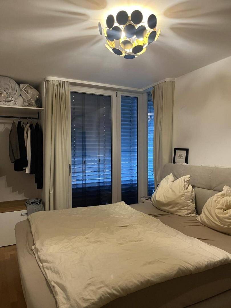 Schlafzimmer mit großem Bett, offenem Kleiderschrank und Zugang zu einem Balkon oder einer Terrasse.