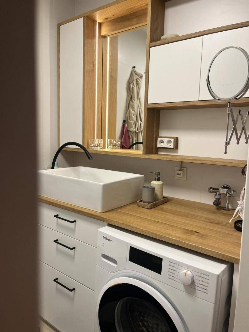 Funktionaler Raum mit Waschmaschine, Waschbecken und Holz-Arbeitsplatte, ideal als Hauswirtschaftsraum.