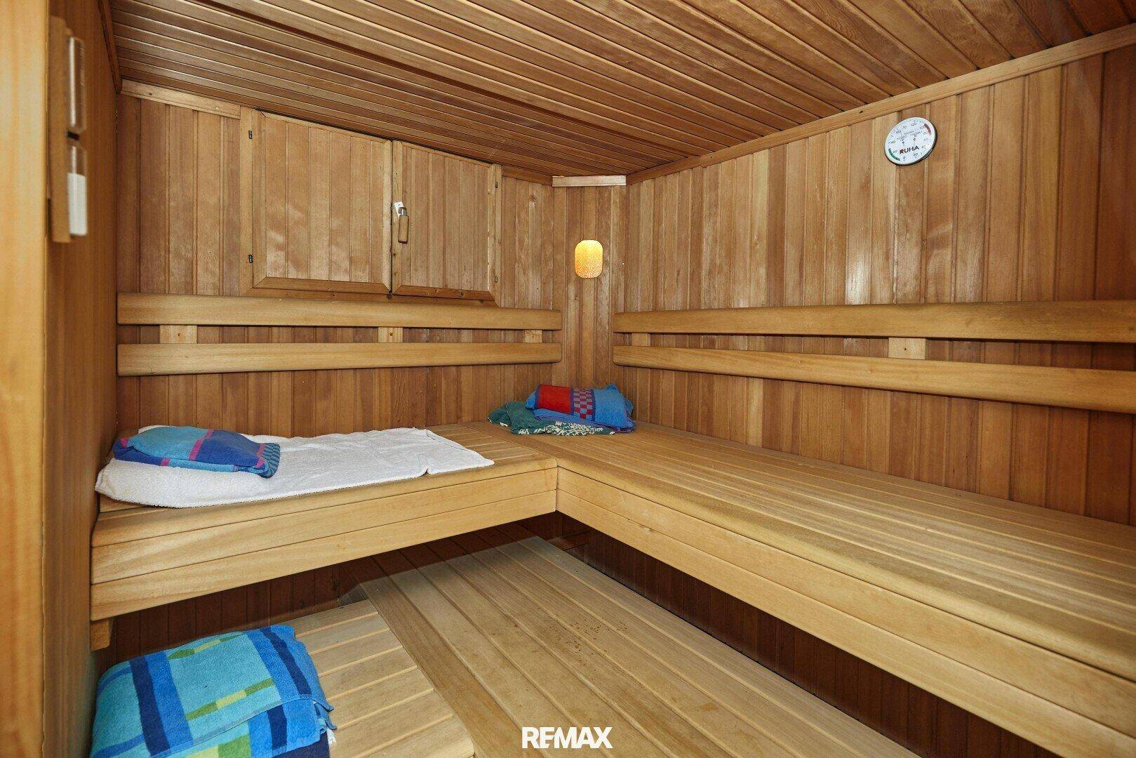 Holzvertäfelte Sauna mit Bänken und traditionellem Design, ideal für Entspannung und Wellness.