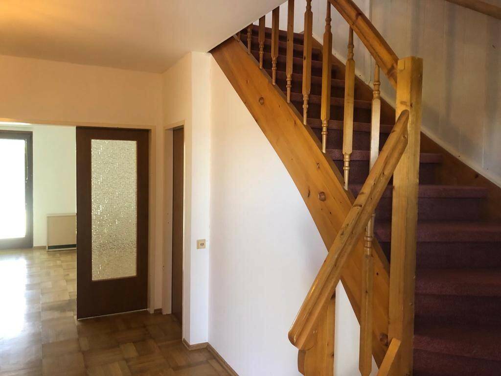 Heller Flur mit Holztreppe und Parkettboden, führt in die oberen Etagen.