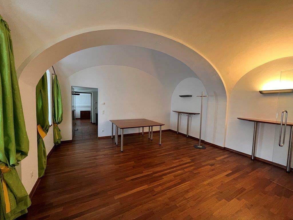 Geräumiger Innenraum mit beeindruckenden Gewölbedecken und elegantem Holzparkettboden.