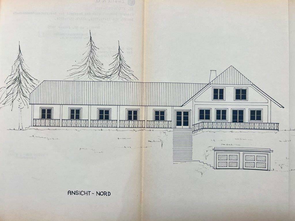 Architektonische Nordansicht des Gebäudes mit Balkon und Garagenzufahrt.
